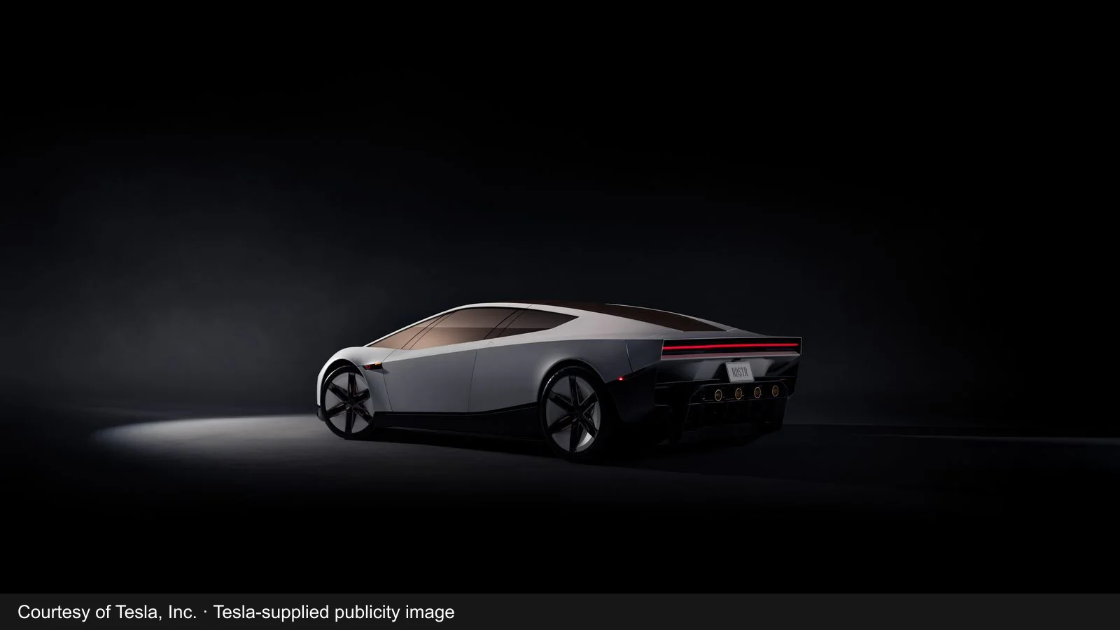 Tesla-supplied publicity image of the new silver Roadster, seen from the rear three-quarter angle in a studio.